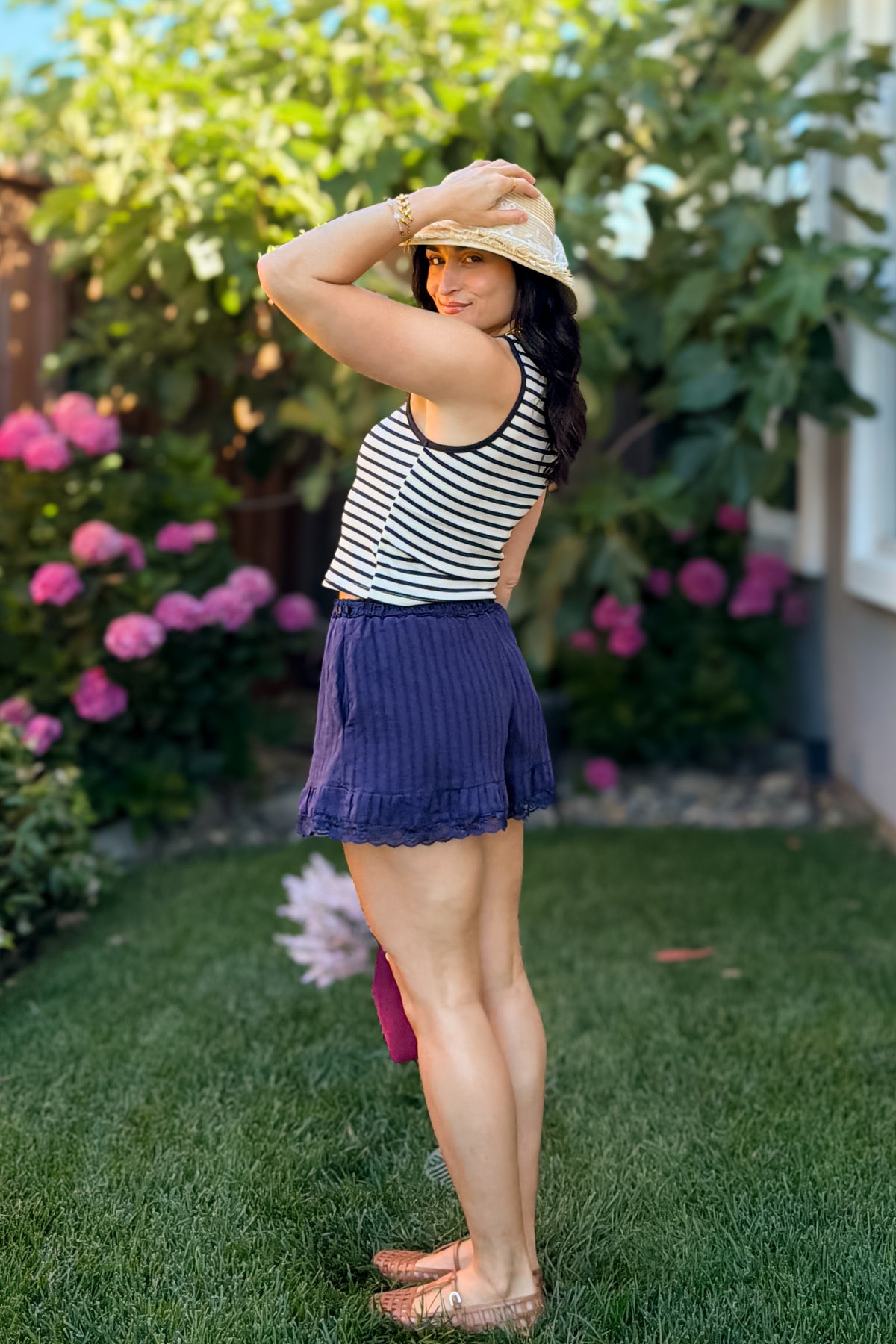 Women's navy lace trim shorts styled with a striped tank and woven flats for everyday summer wear.