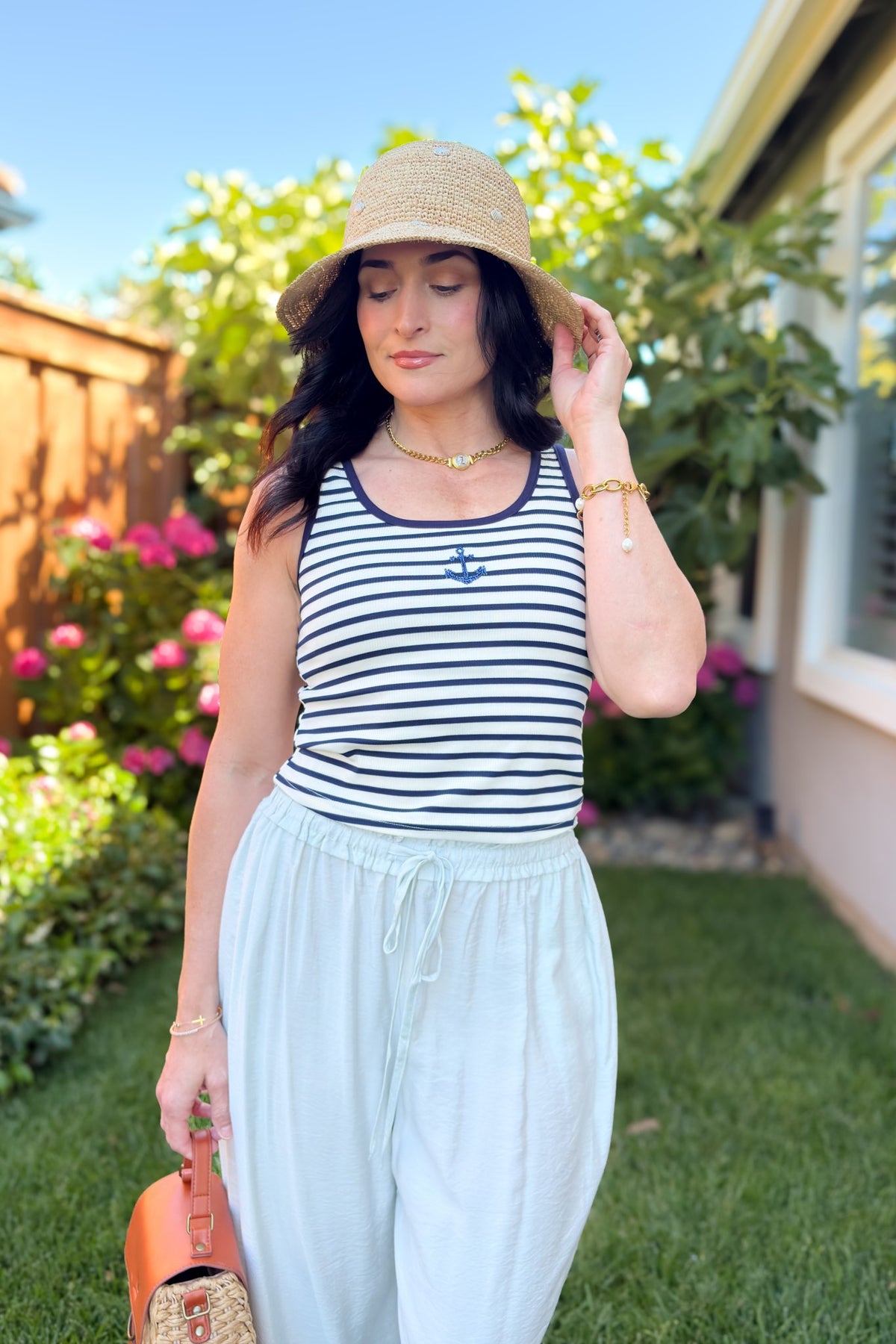 Navy striped tank top with beaded anchor detail paired with soft mint bloomer pants and straw hat and handbag