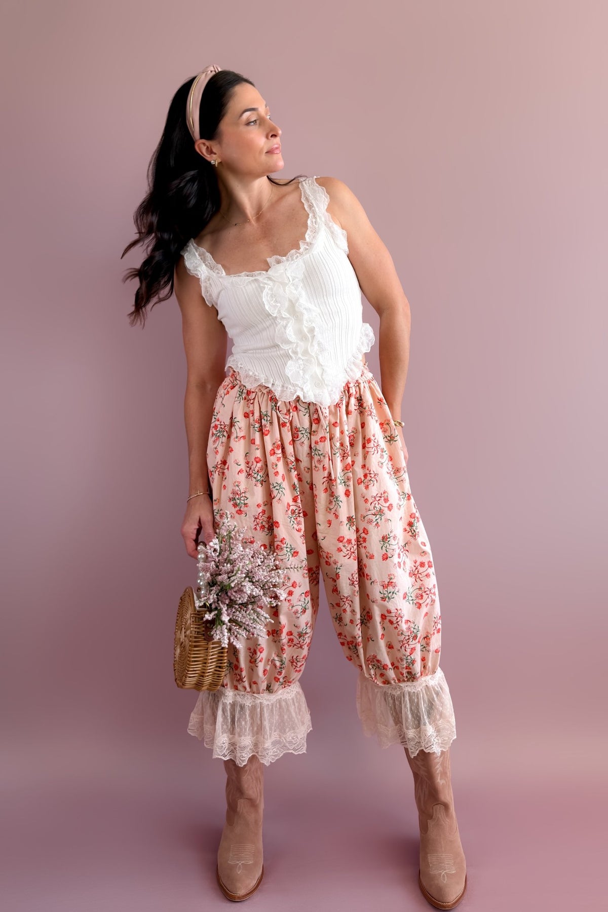 Pink floral statement pants with red botanical print and delicate ivory lace trim styled with neutral western boots