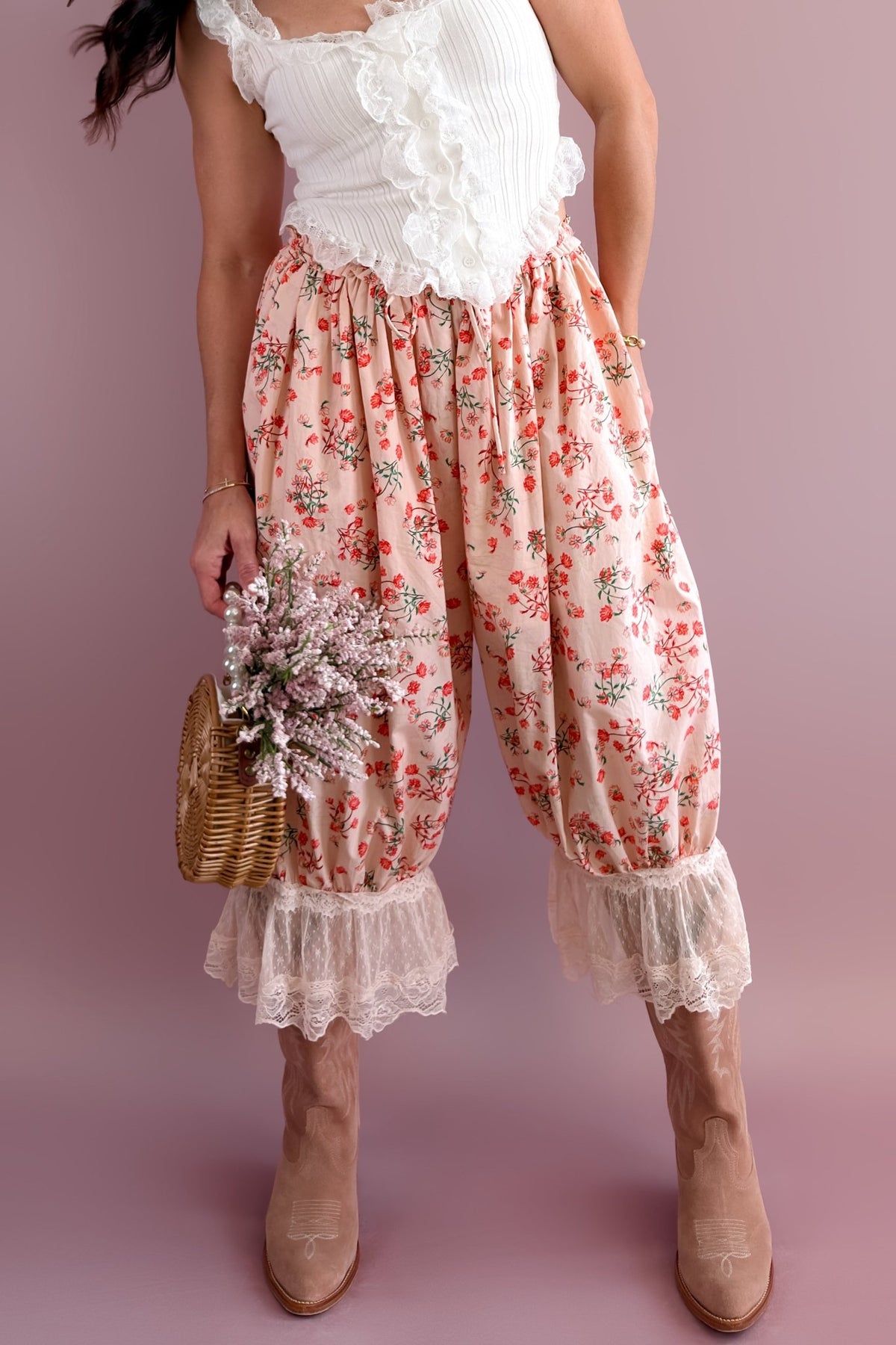 Woman wearing a white ribbed lace ruffle tank with blush floral bloomer pants and a soft pink headband
