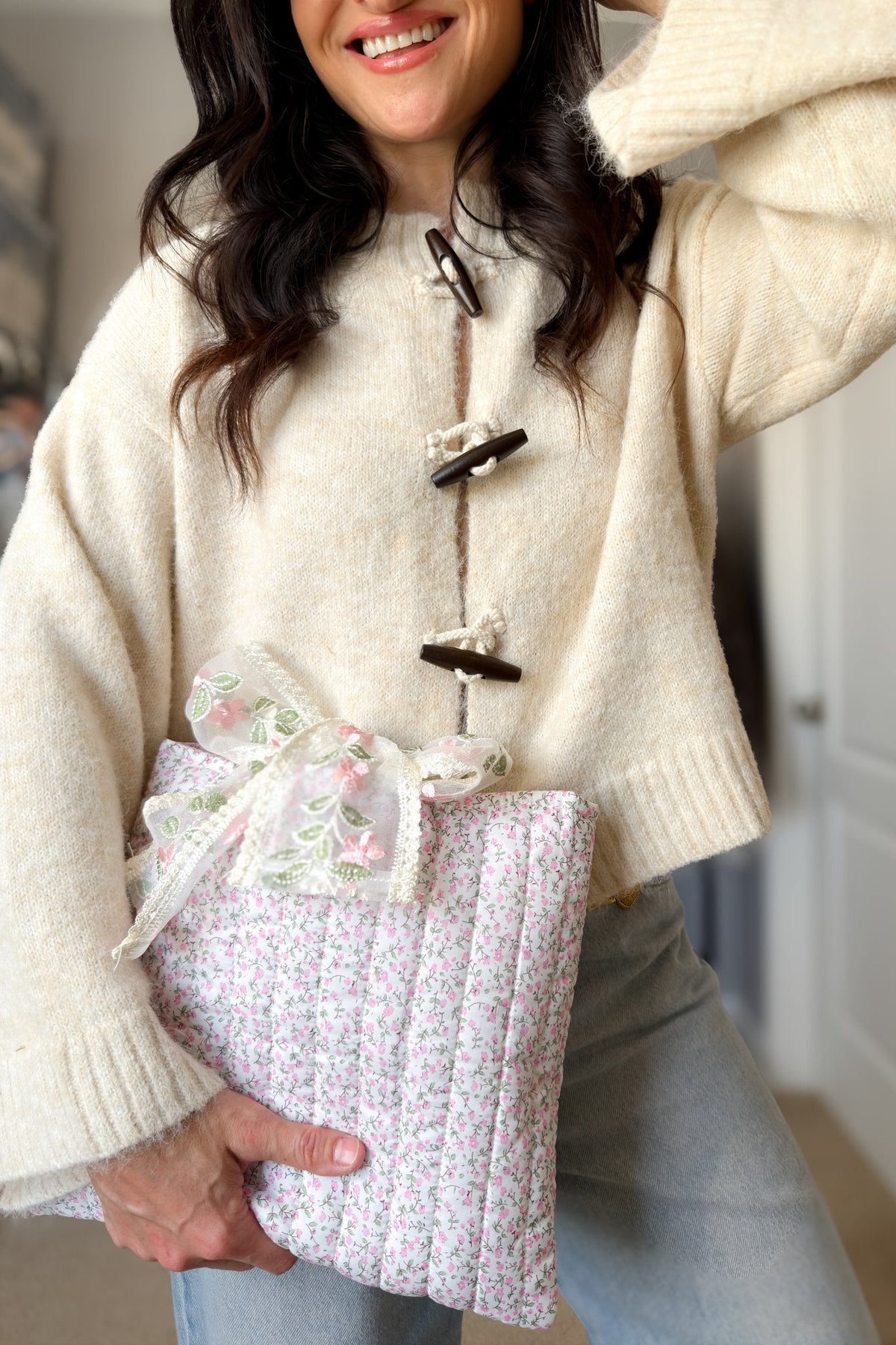 Woman holding a pink floral Bible cover with vertical quilting and oversized embroidered floral bow
