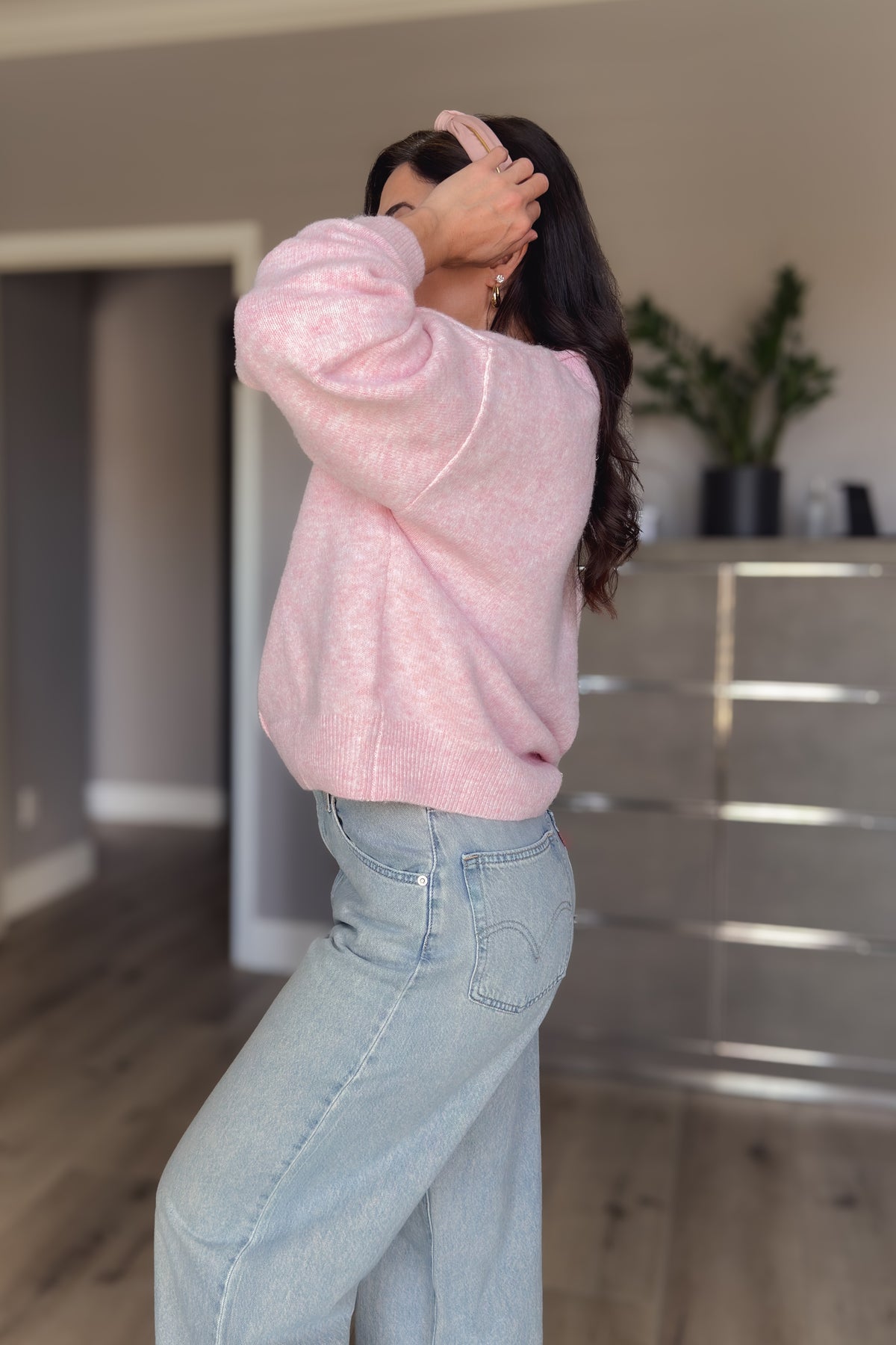 Pink women’s cardigan sweater shown from the back with a relaxed fit and soft lightweight knit texture.
