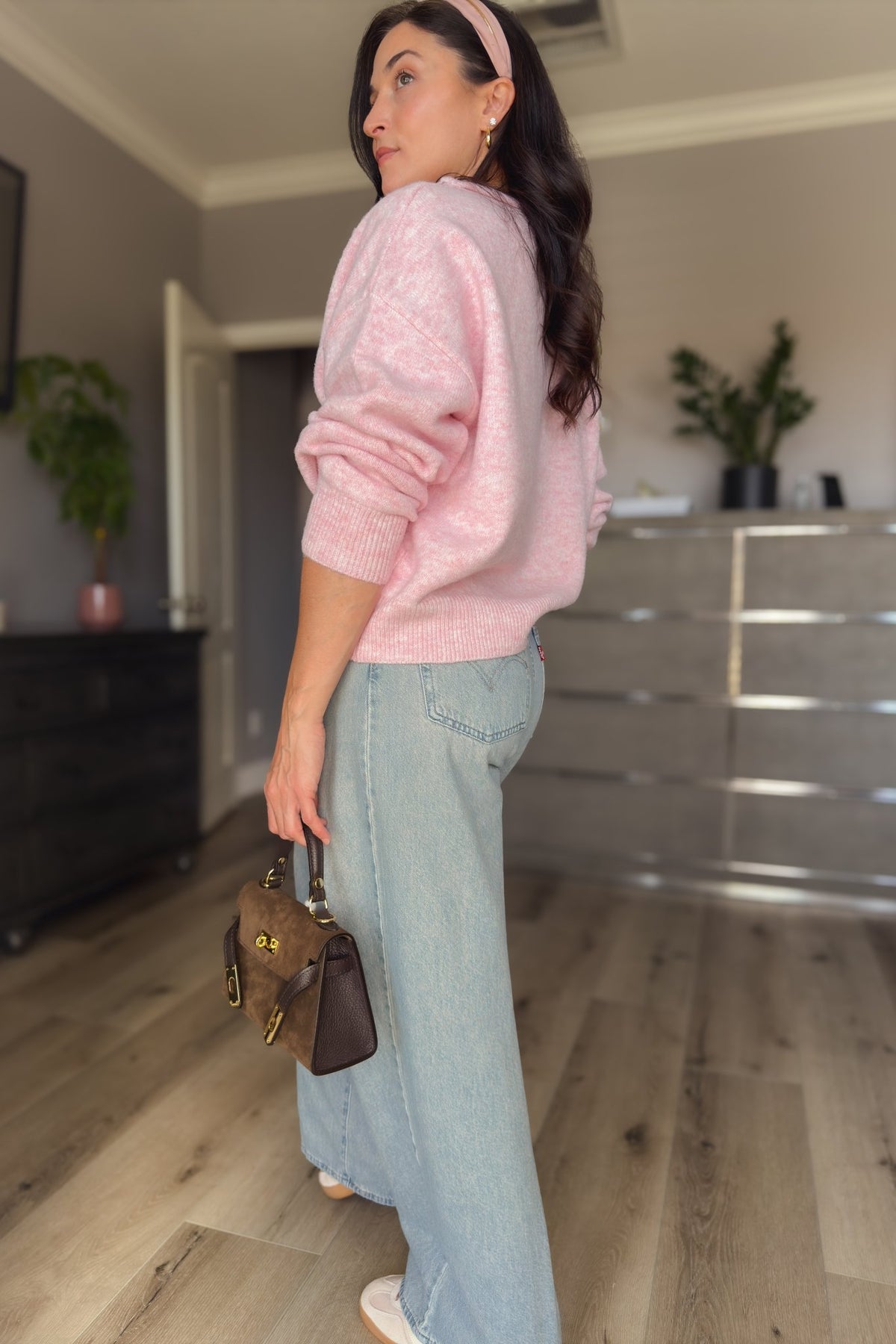 Women’s pink cardigan sweater styled open at the neckline with light wash denim for a versatile year-round outfit.
