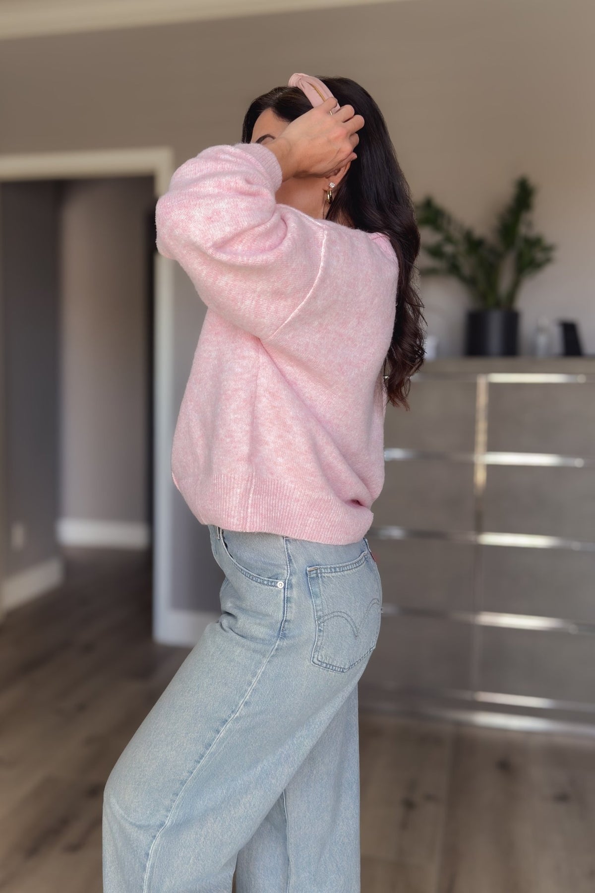 Pink women’s cardigan sweater shown from the back with a relaxed fit and soft lightweight knit texture.