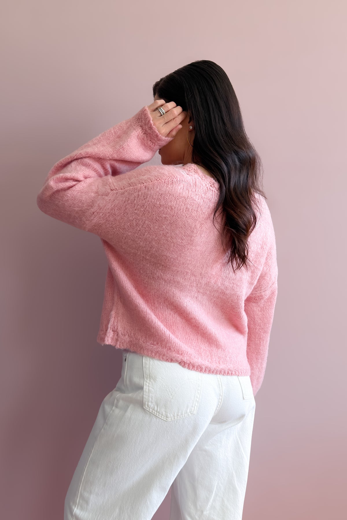 Delicate pink knit sweater with decorative front buttons and romantic pointelle pattern through the front