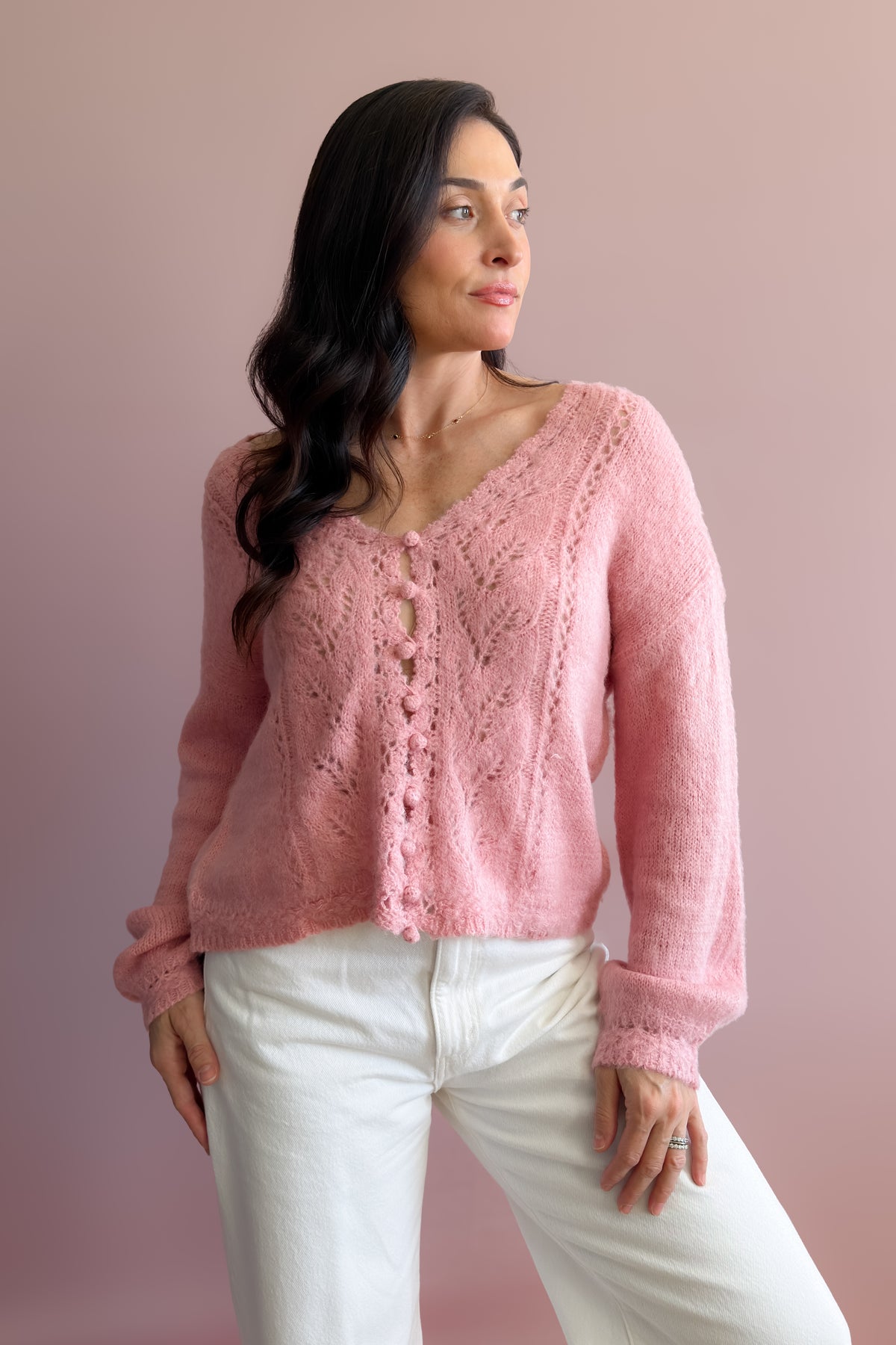 Feminine pink knit sweater with lightweight texture, relaxed drape, and subtly shaped balloon sleeves