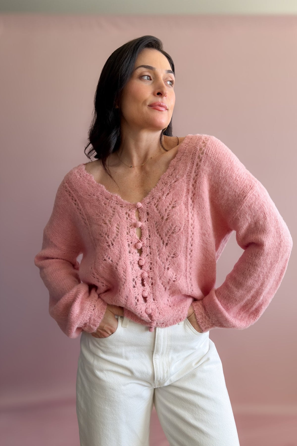 Women’s pink V-neck sweater with delicate pointelle detailing, drop shoulders, and soft balloon sleeves