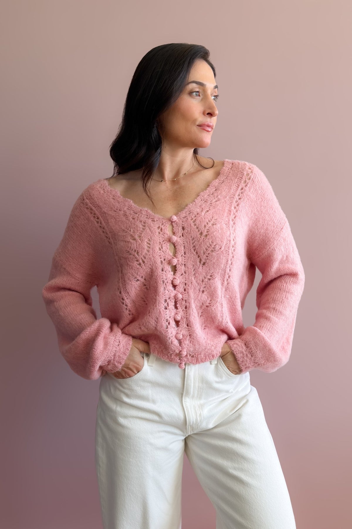Pink pointelle V-neck sweater with long sleeves, drop shoulder, and soft textured knit finish