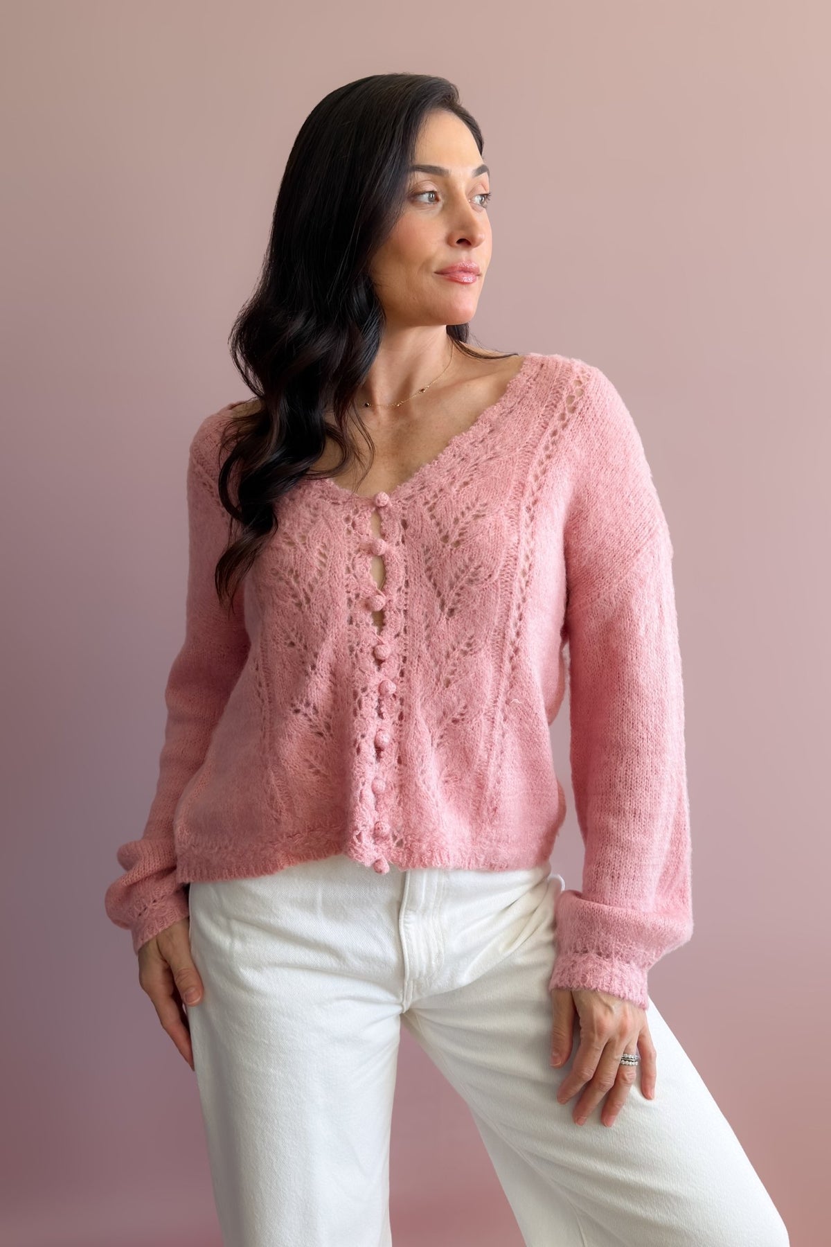 Feminine pink knit sweater with lightweight texture, relaxed drape, and subtly shaped balloon sleeves