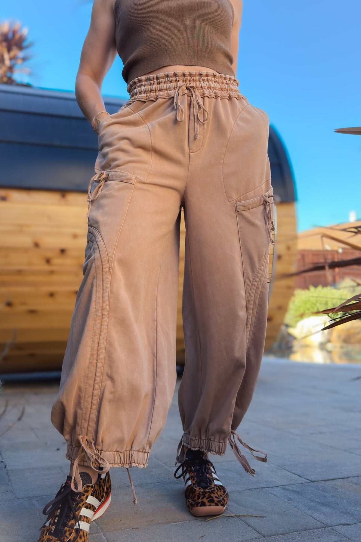 Tan mineral wash wide leg cargo pants for women styled with brown tank and pink cardigan