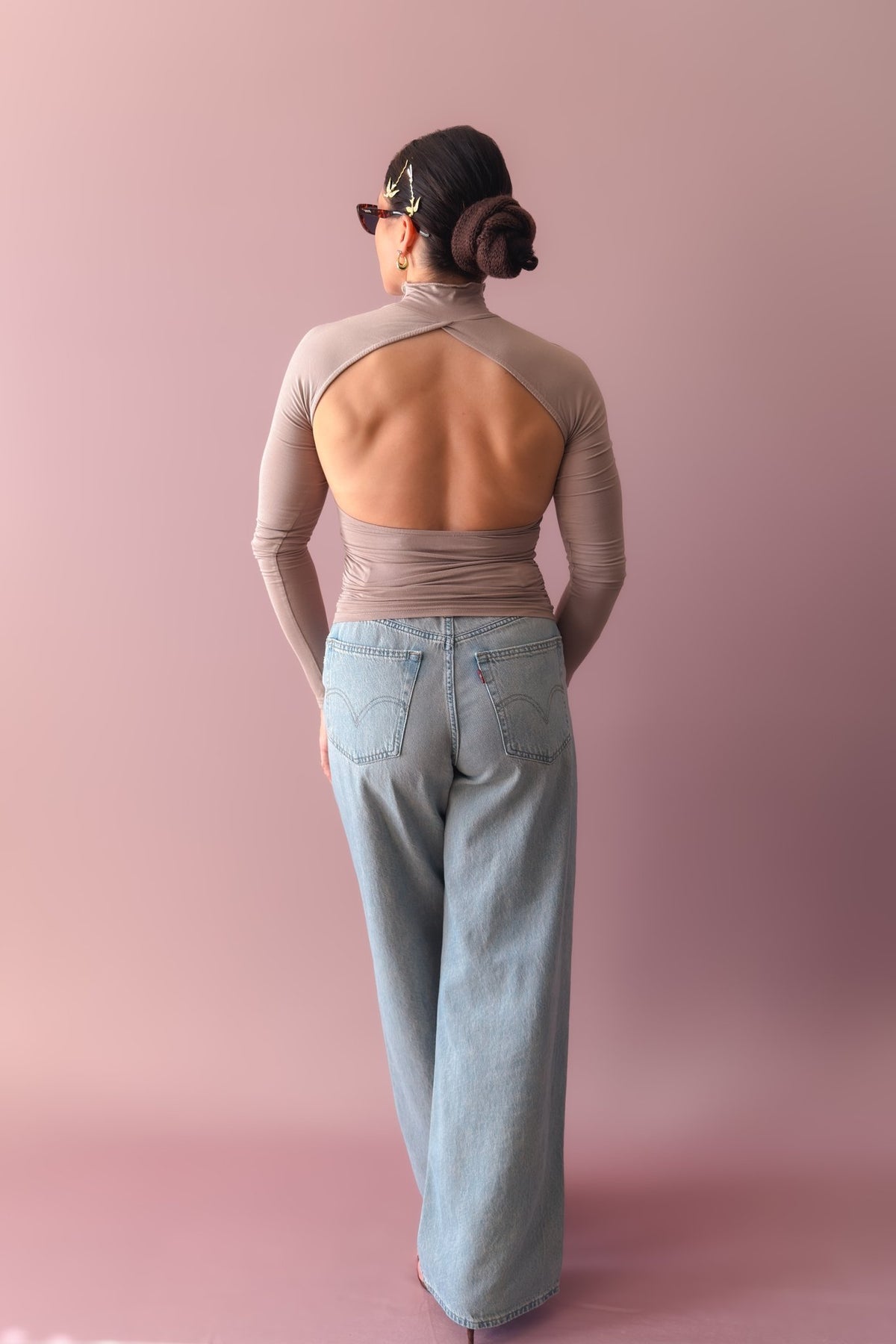 Back view of taupe turtleneck top showing dramatic open back cutout