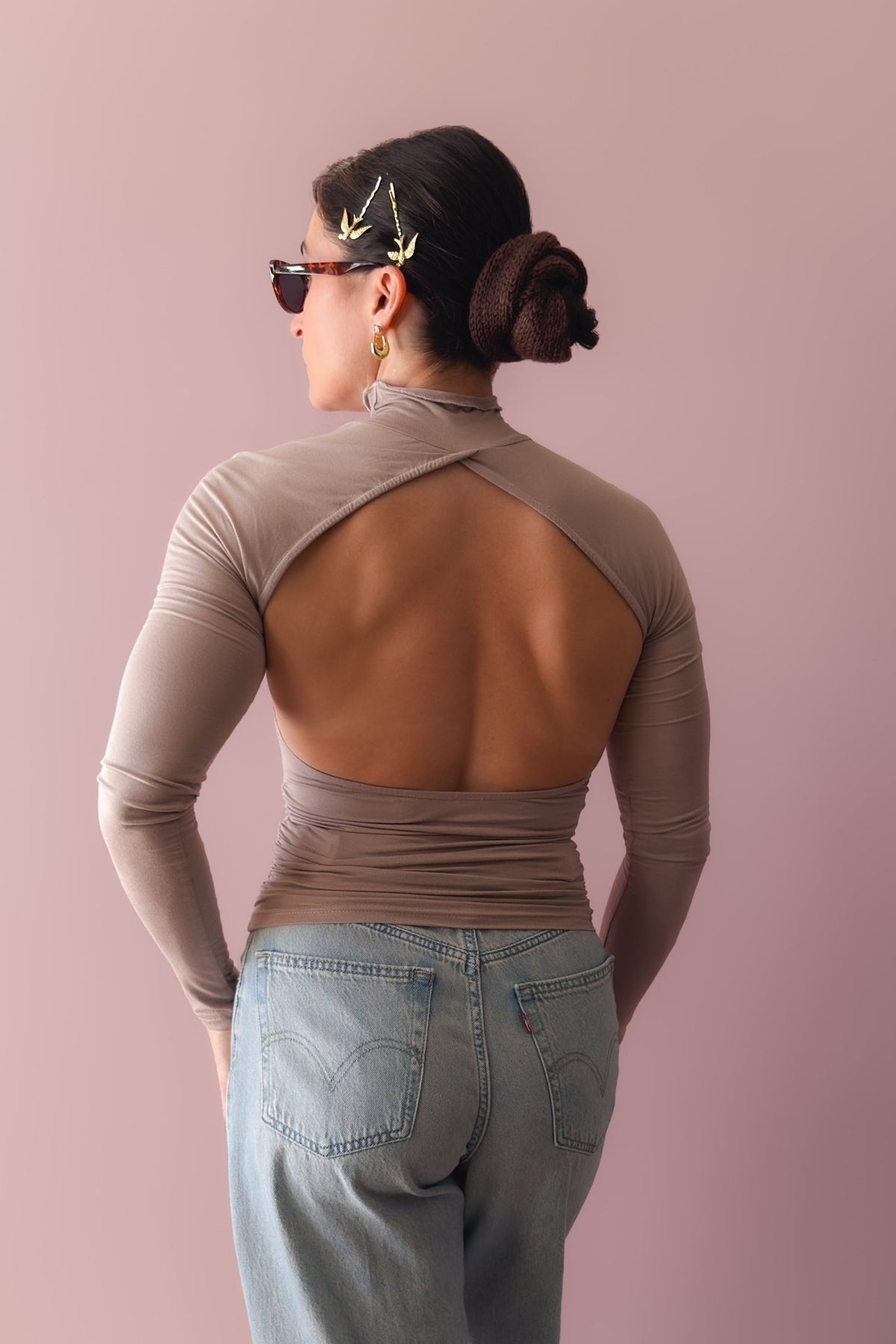 Taupe long sleeve turtleneck with open back design and body-skimming fit