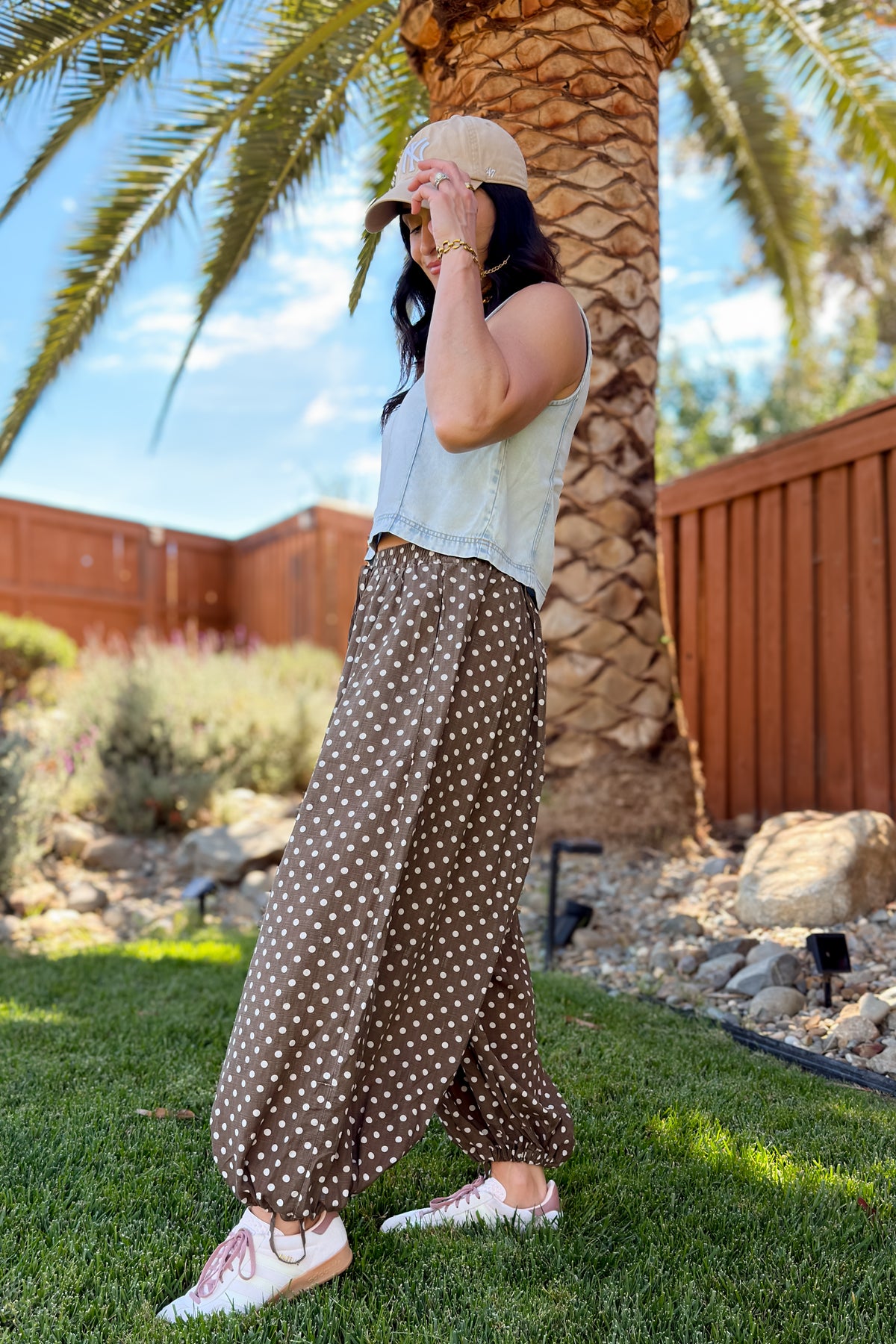 Relaxed brown polka dot statement pants styled with pink and white sneakers.