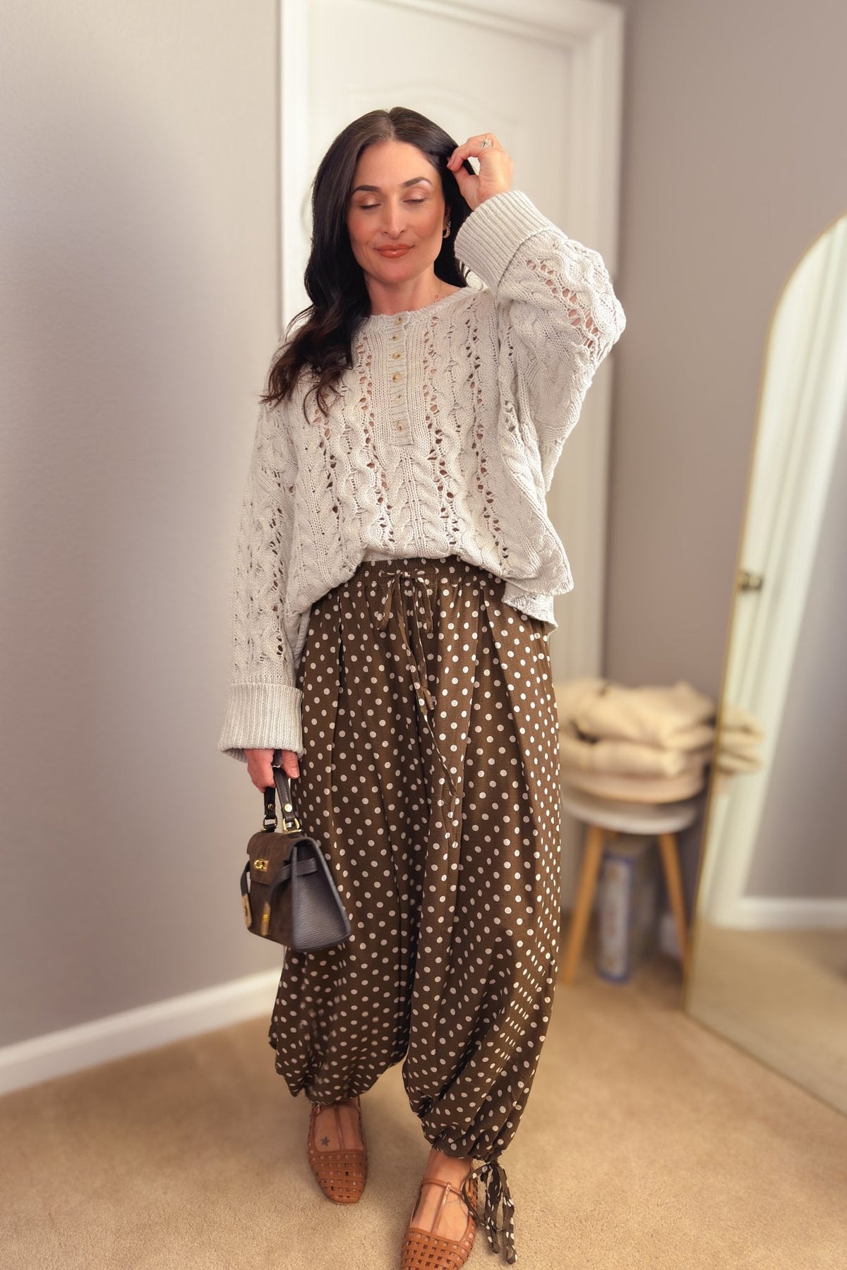 Brown and cream polka dot balloon pants with a relaxed wide-leg silhouette, adjustable ankle ties and drawstring waist.