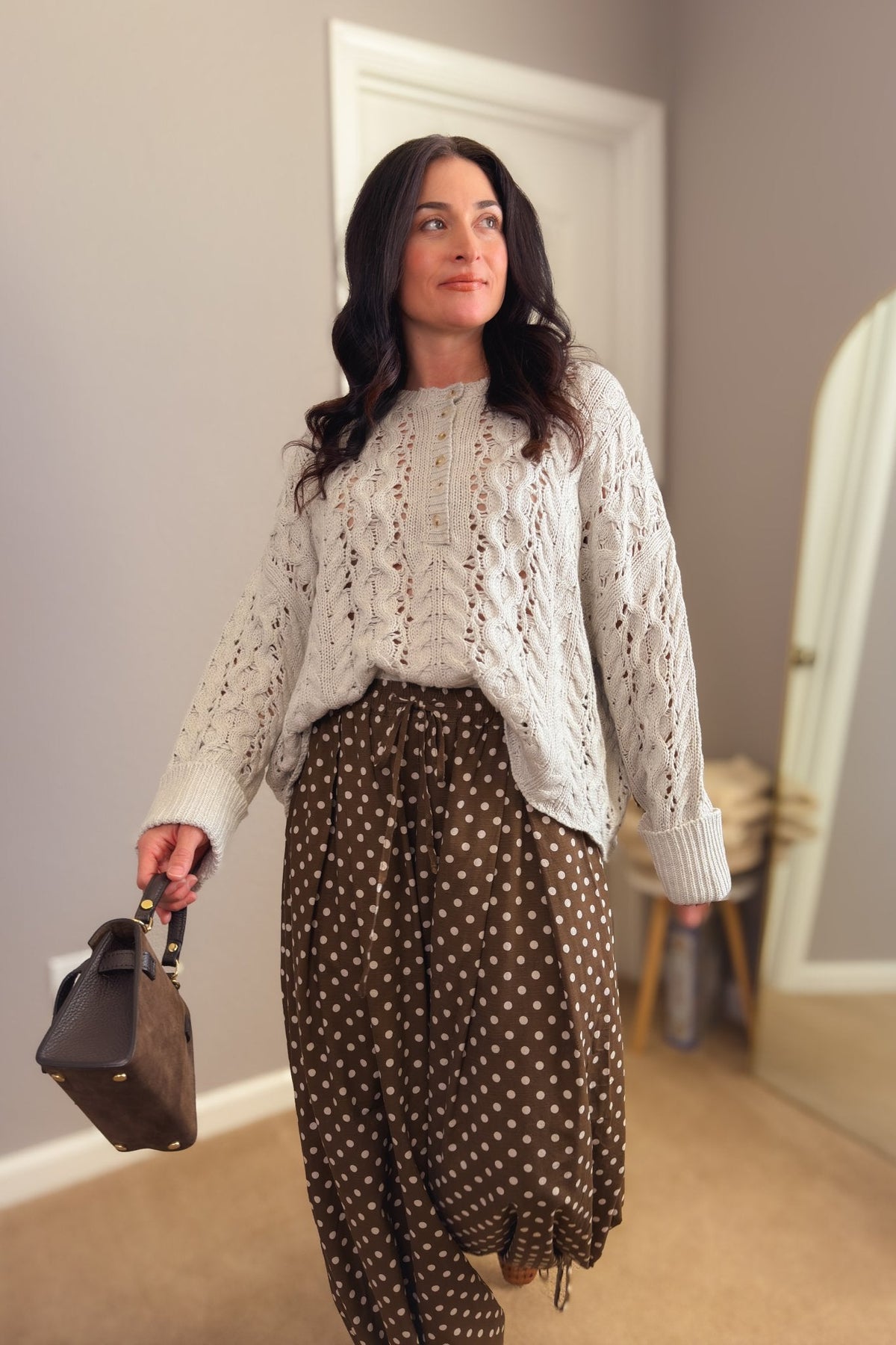 Side view of brown polka dot balloon pants showing the voluminous leg shape and adjustable gathered ankle detail.