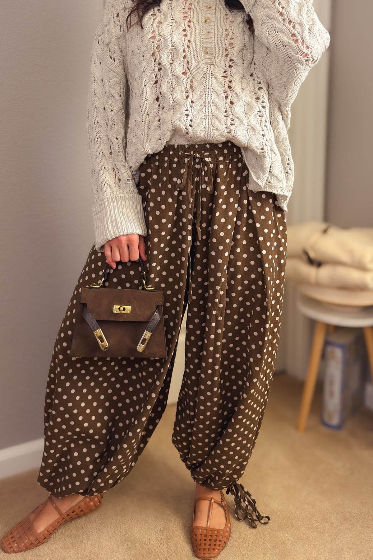 Brown polka dot balloon pants styled with an ivory cable knit sweater and woven flats for a feminine fall outfit.