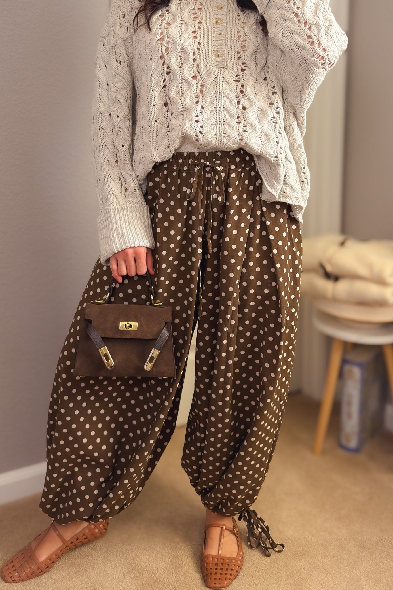 Brown polka dot balloon pants styled with an ivory cable knit sweater and woven flats for a feminine fall outfit.