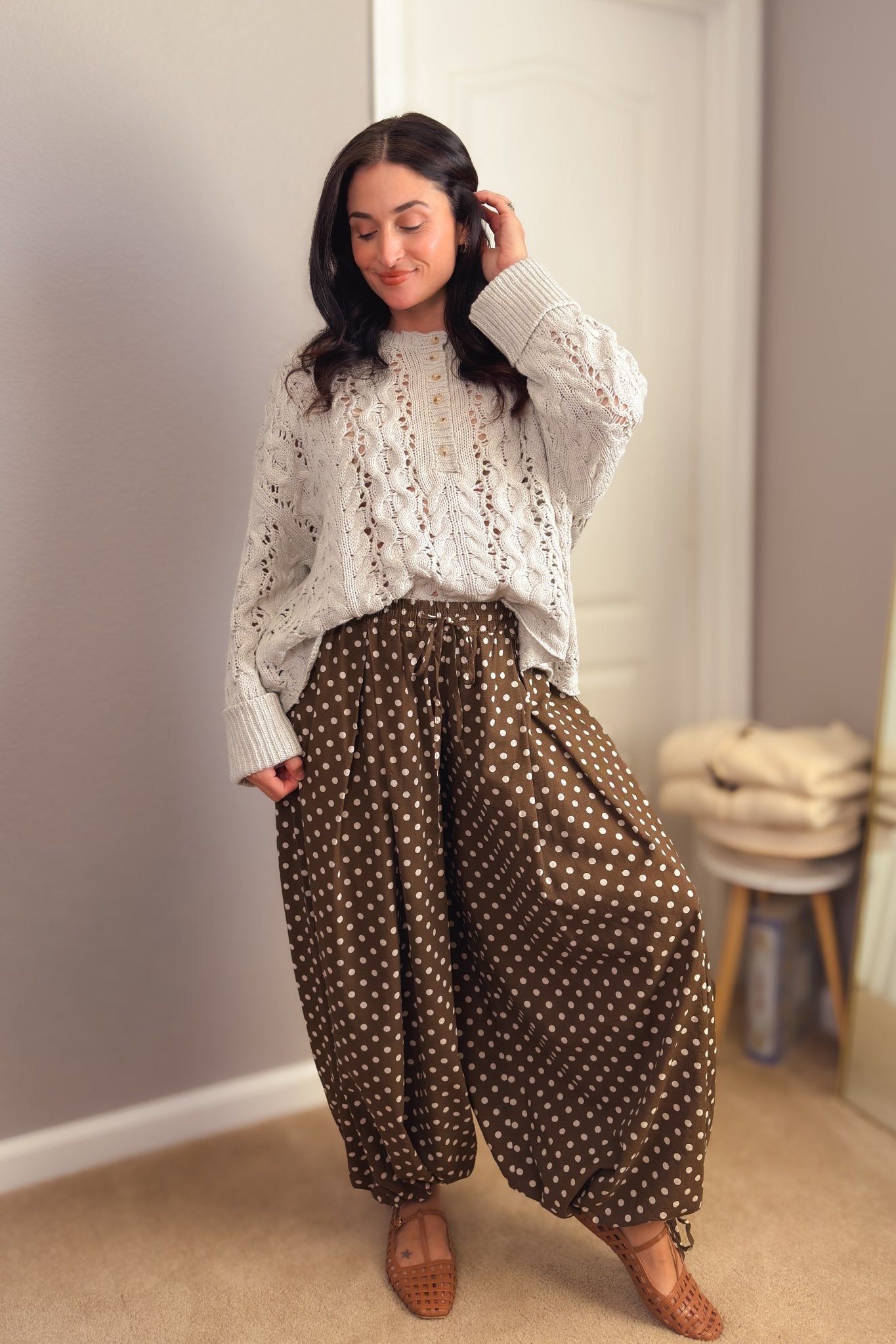Brown polka dot balloon pants styled with an ivory cable knit sweater and woven flats for a feminine fall outfit.