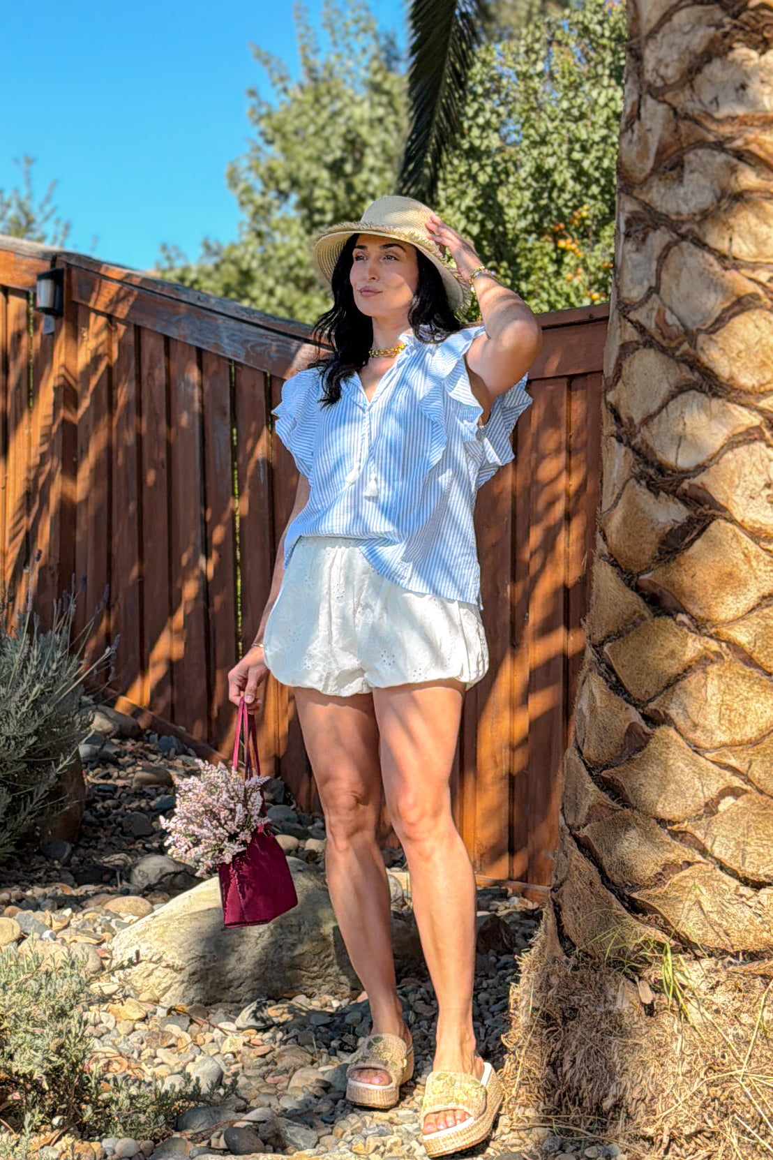 Feminine summer outfit featuring white eyelet bubble shorts crafted from breathable 100% cotton with embroidered details.