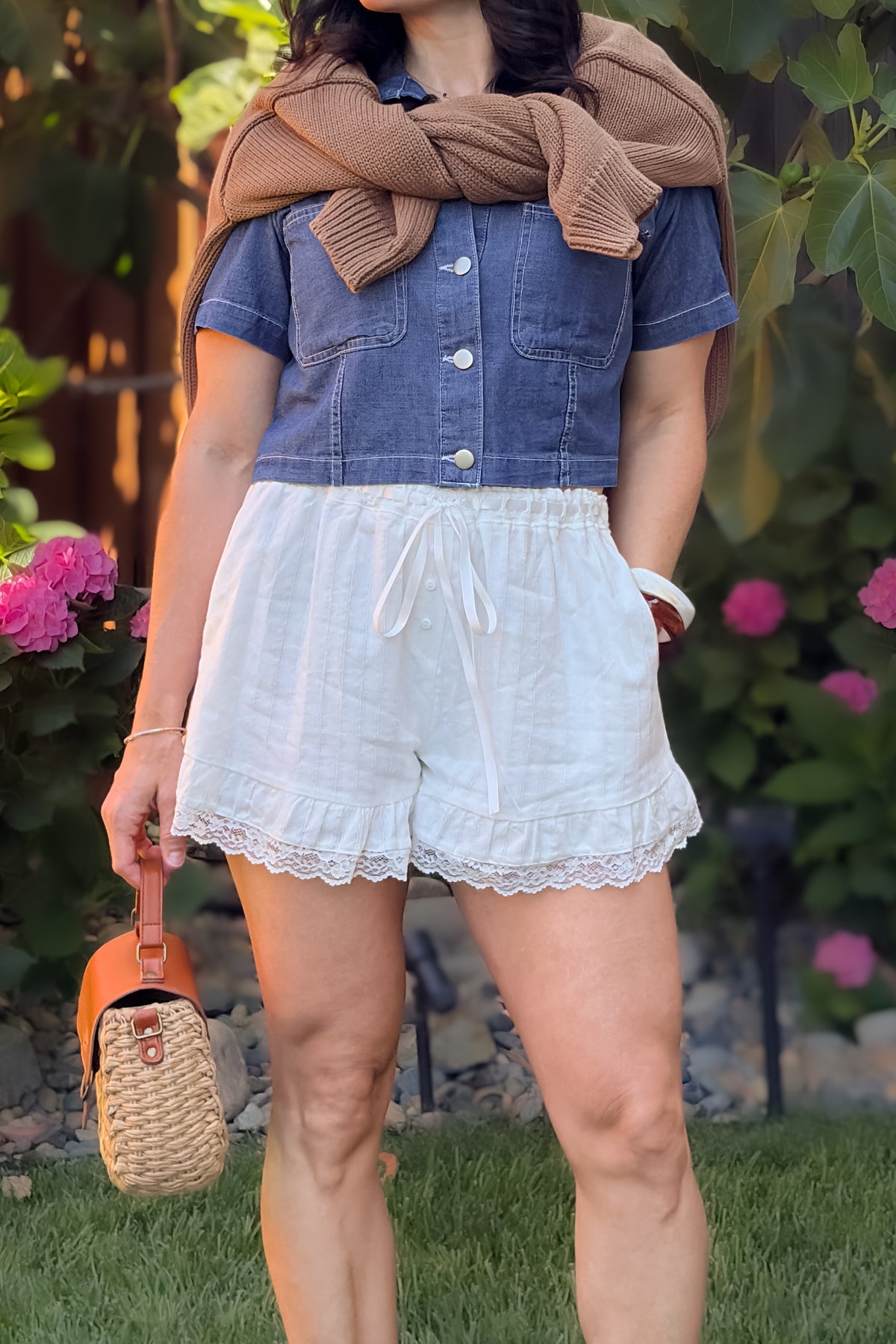 White lace trim shorts with soft elastic drawstring waistband, pockets, and delicate lace hem detail.