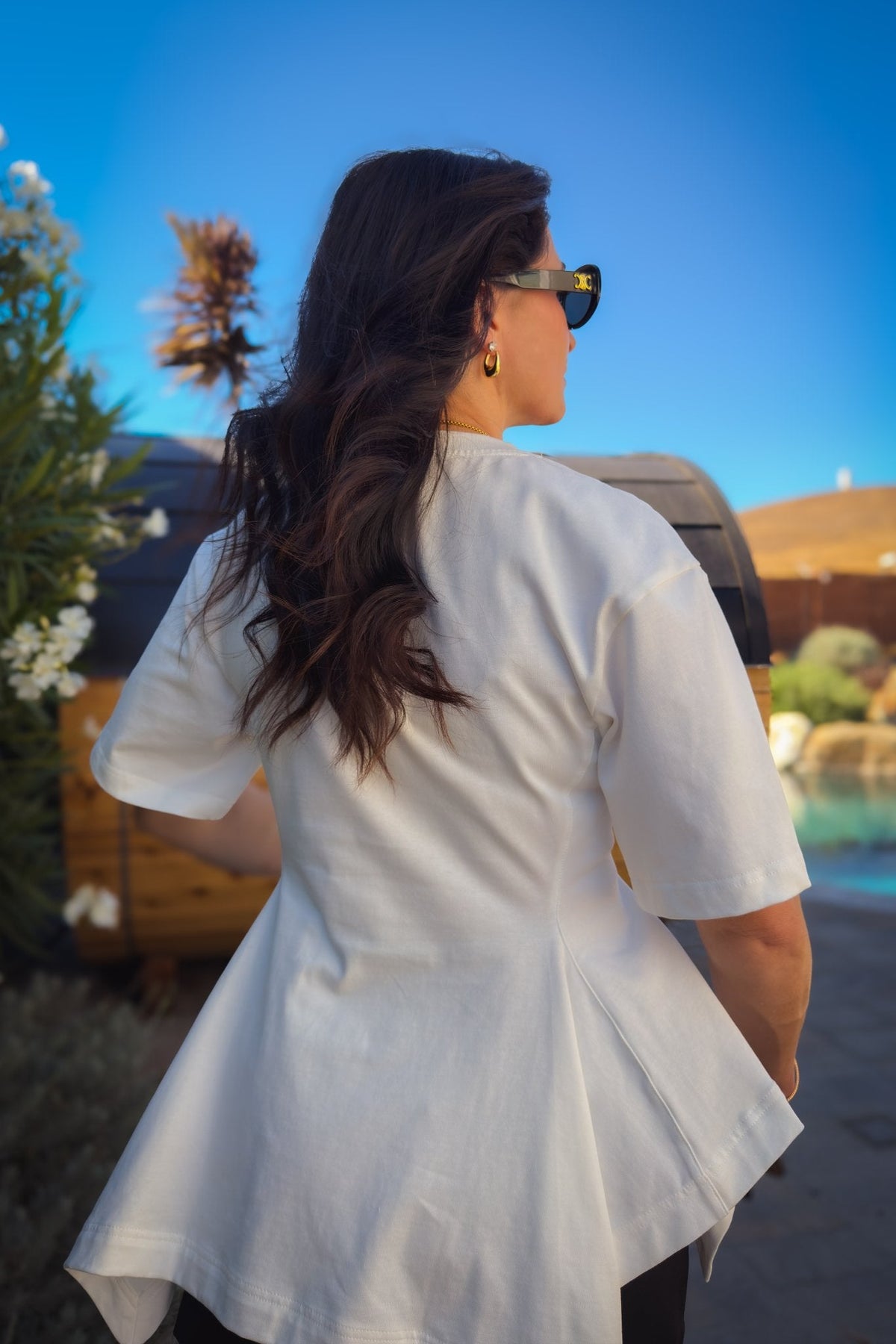 White cotton peplum top with oversized sleeves, structured fabric and a feminine flared hem styled with denim.