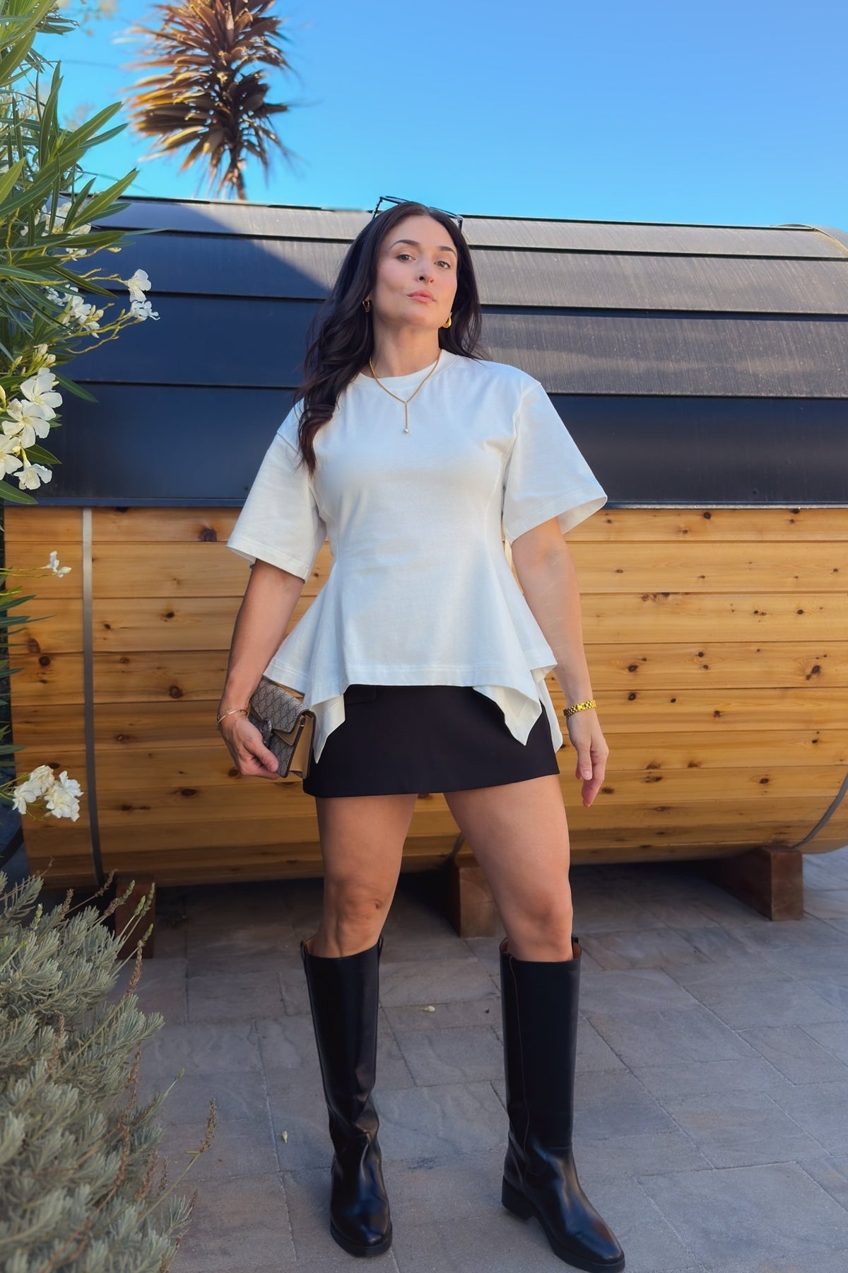 White waist-defining cotton top with oversized sleeves and a structured peplum hem for an elevated everyday outfit.