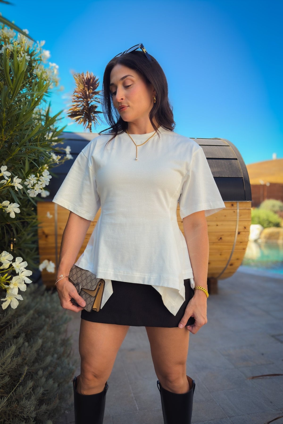 White heavyweight cotton peplum tee styled with jeans, featuring oversized sleeves and a chic sculpted waist.