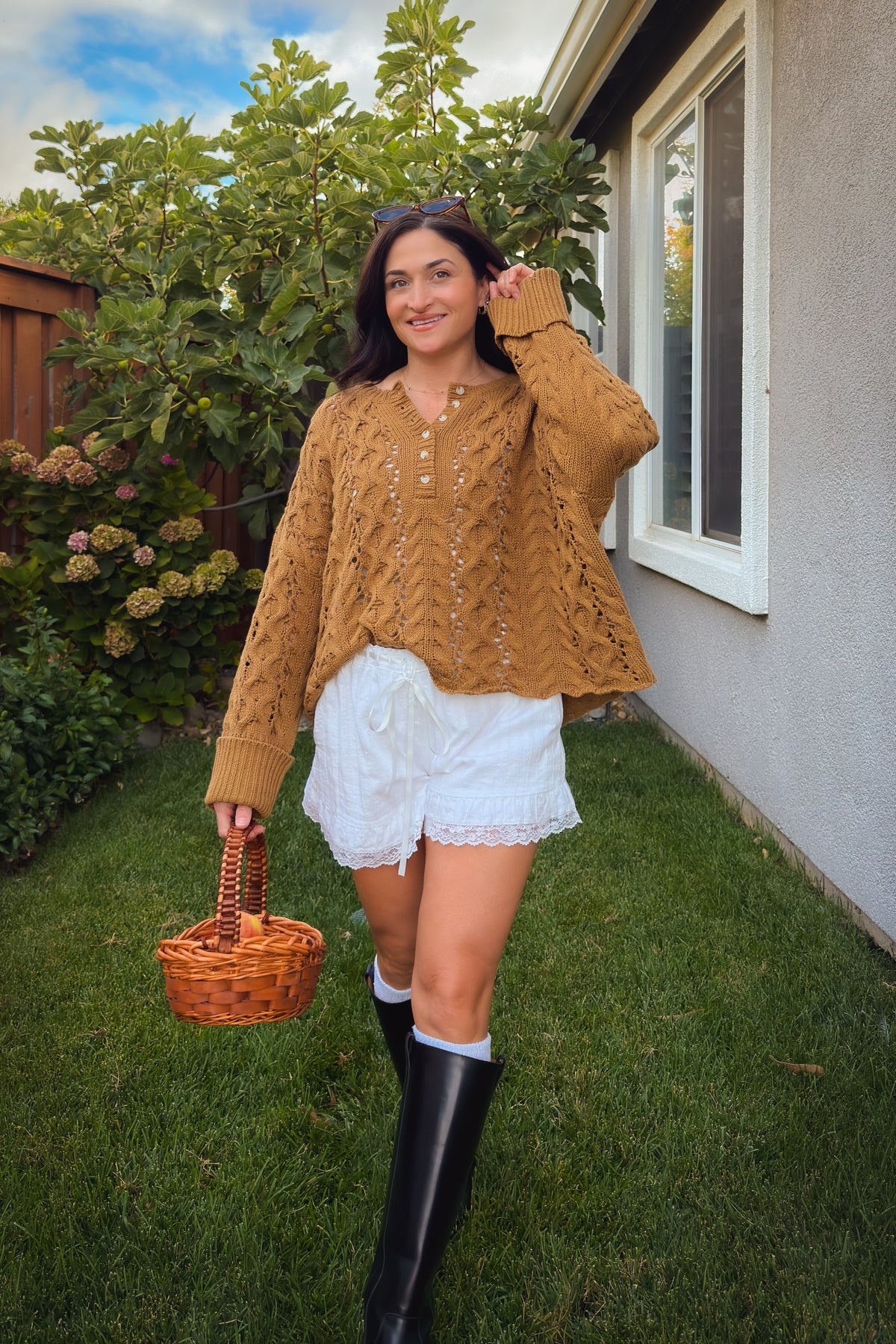 Oversized Henley knit sweater with openwork cable design and wide ribbed cuffs