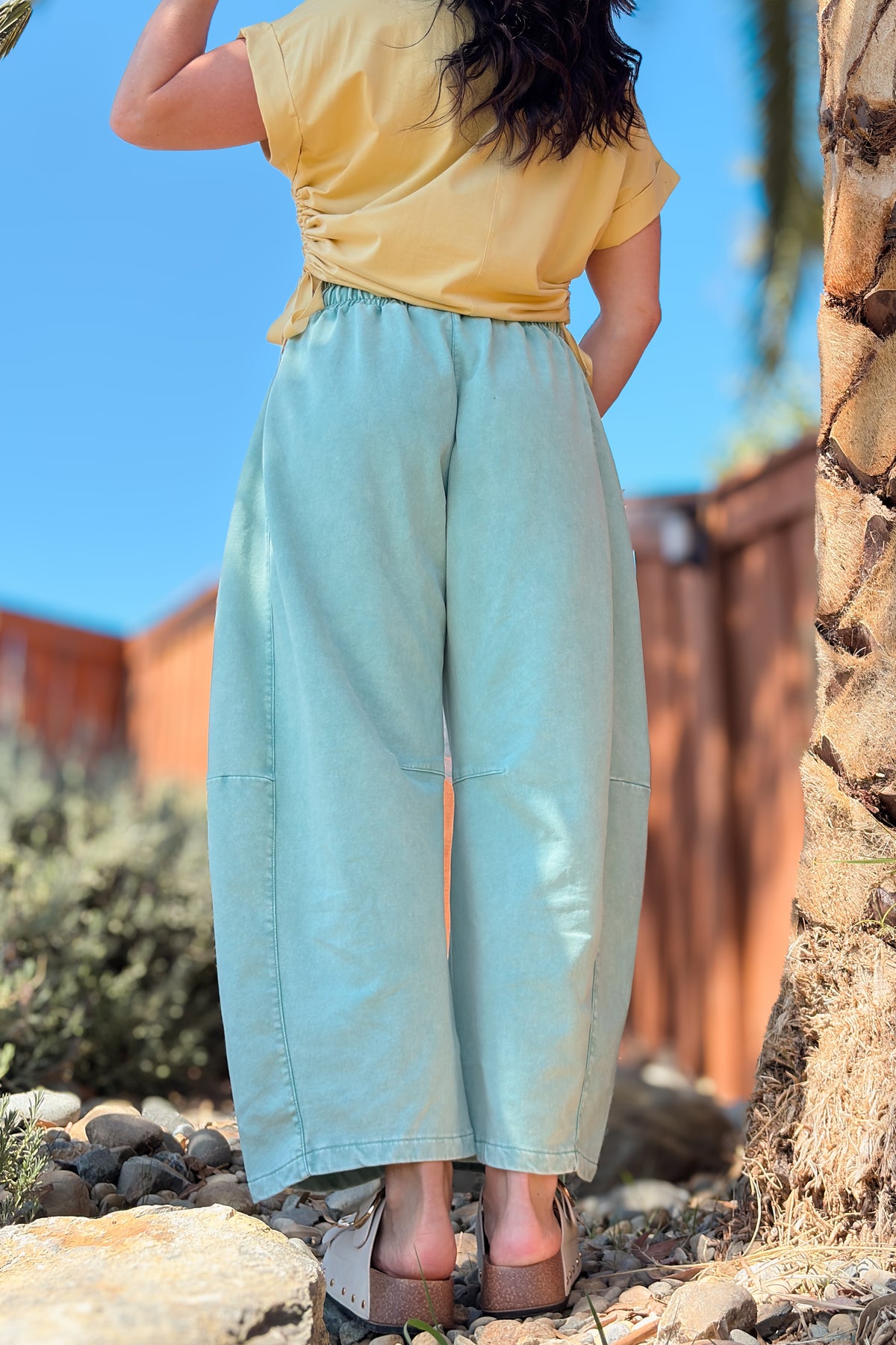 Back view of green barrel leg pants featuring soft French terry fabric and a comfortable pull-on waistband.