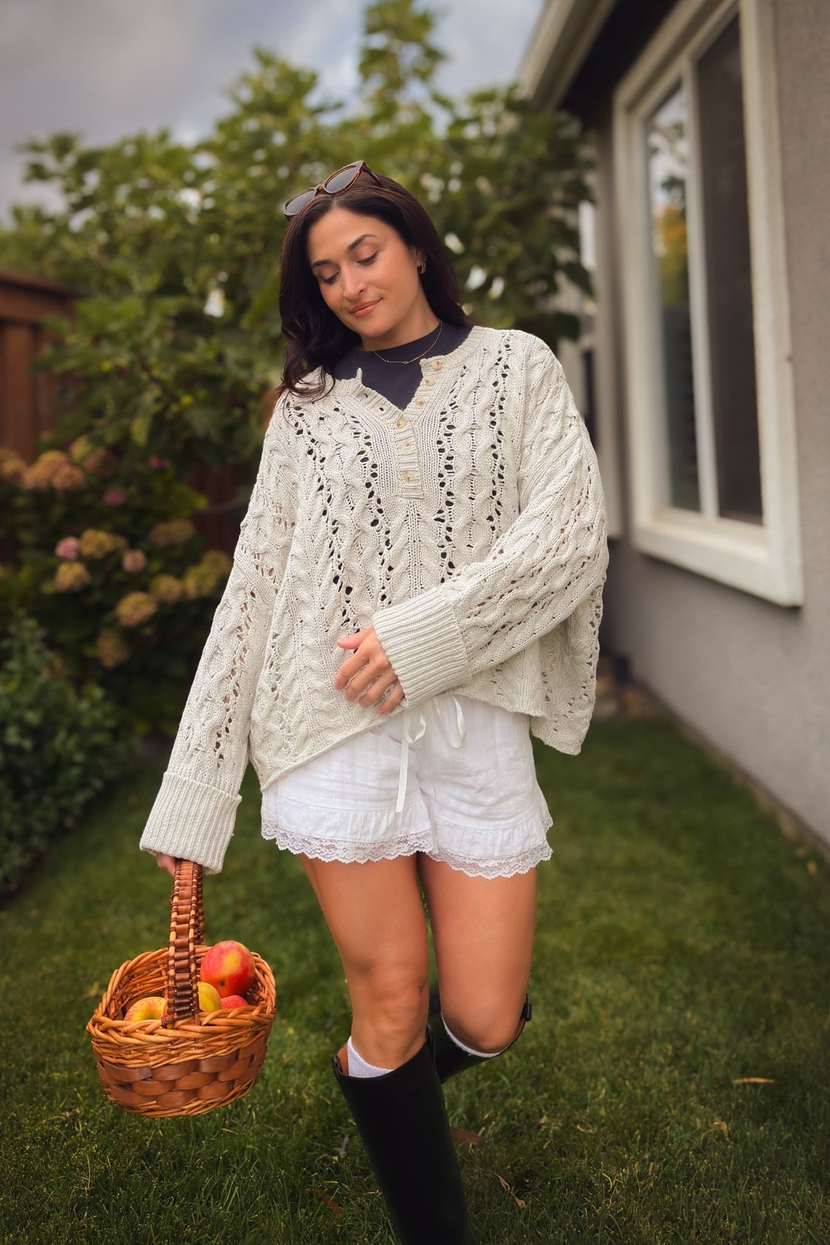 Light gray open knit cable Henley sweater with oversized fit and textured pointelle detail.