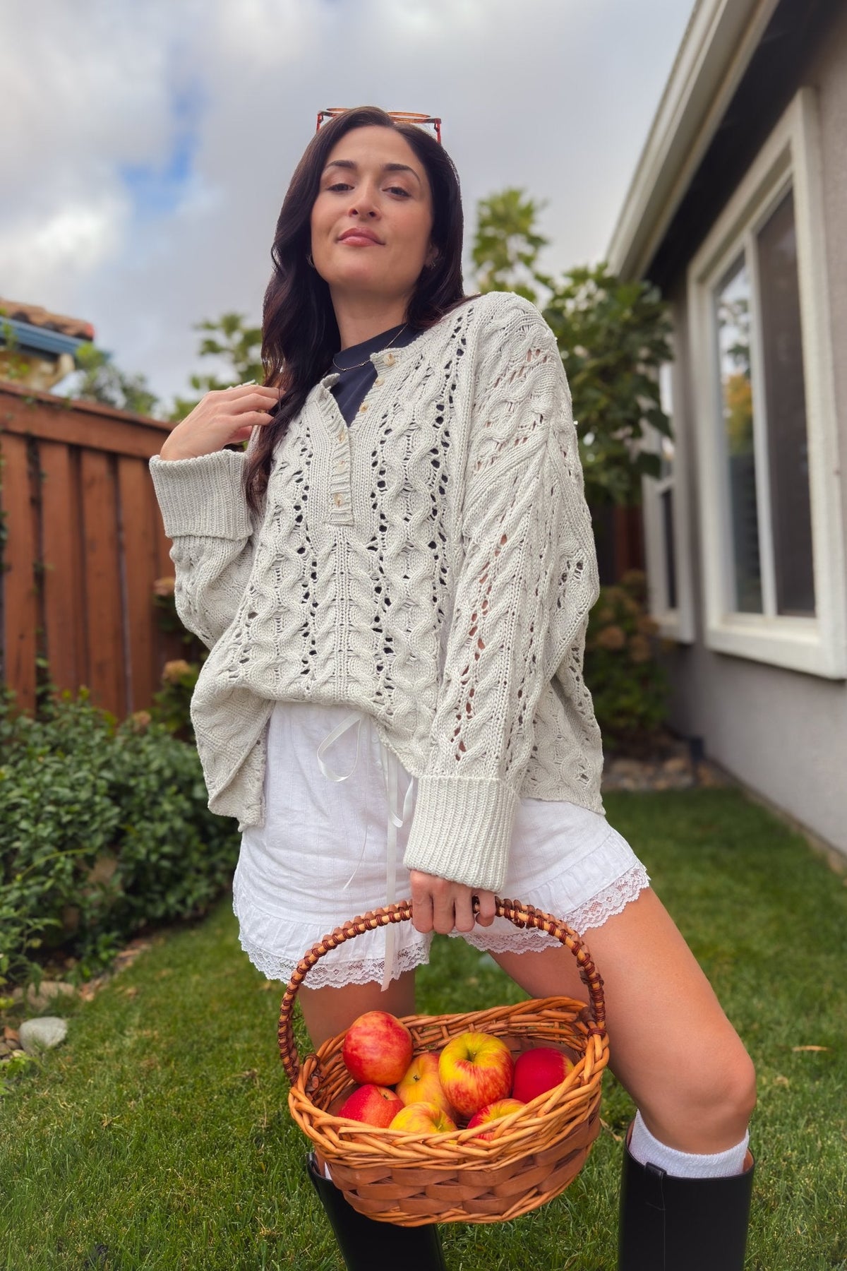 Light gray pointelle cable knit sweater with long sleeves, ribbed cuffs, and easy layering fit.