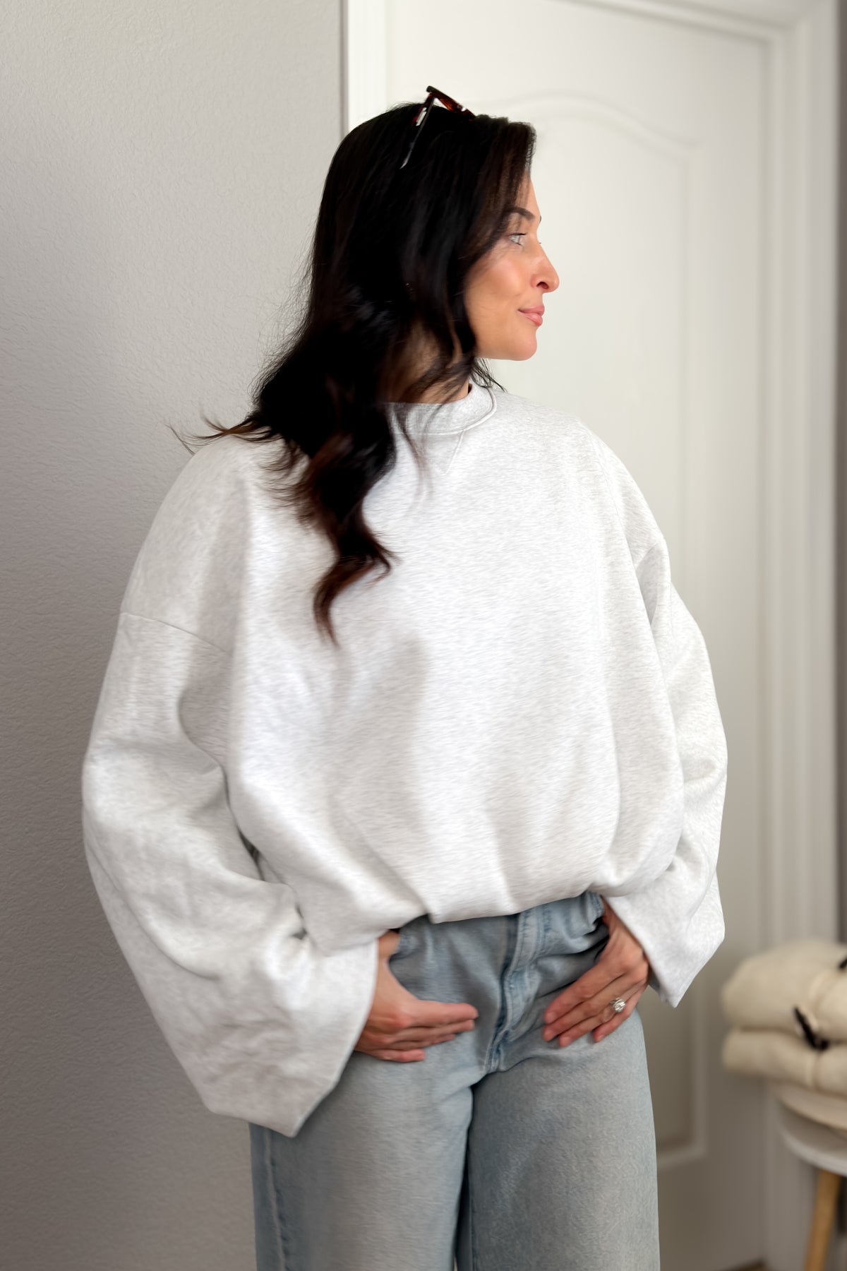 Light heather gray boxy sweatshirt with oversized sleeves and relaxed fit styled with wide leg denim.
