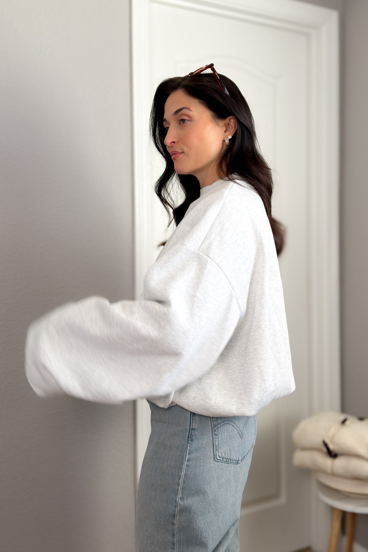 Women’s oversized gray crewneck sweatshirt styled casually with pink satin shorts for a cozy lounge outfit.