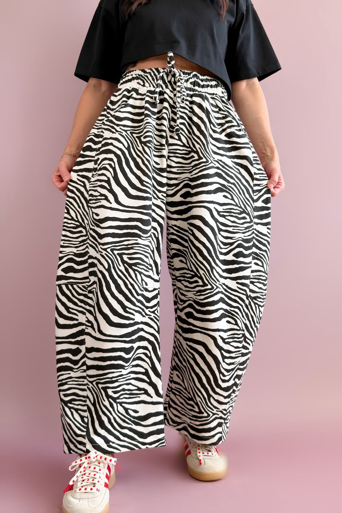Black and ivory zebra barrel pants styled with a black lace-trim cropped tee and casual white sneakers