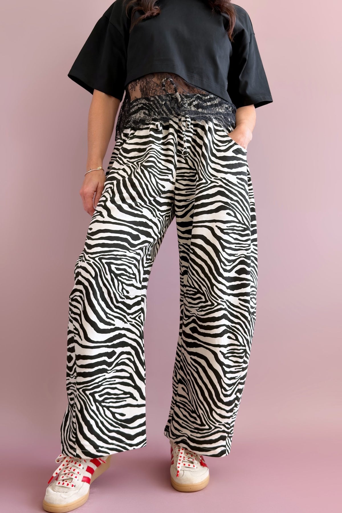 Side view of women’s black and ivory zebra barrel pants styled with a black top and white sneakers